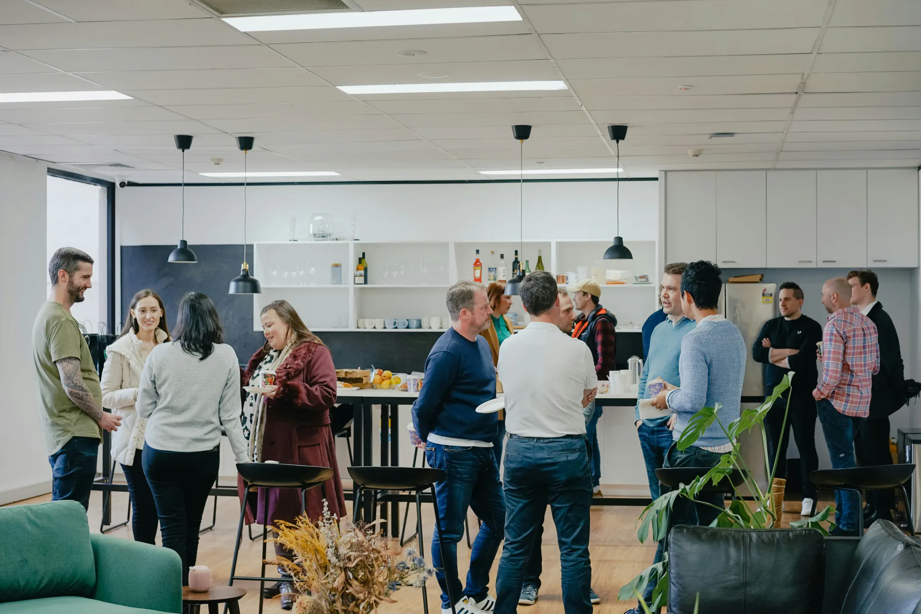Business-casual groups connecting in a bright shared lounge